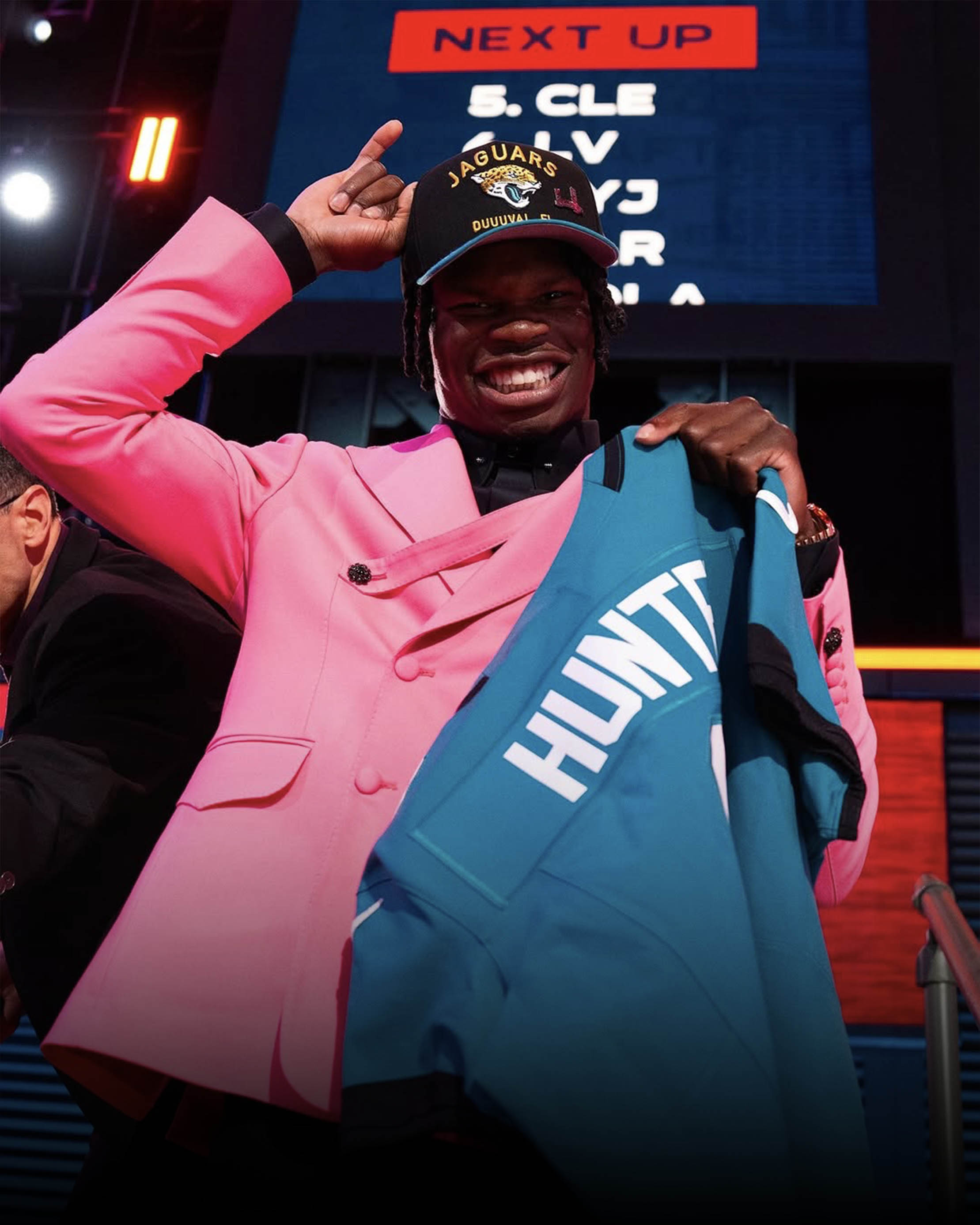 Travis Hunter holds up his Jacksonville Jaguars jersey after being drafted