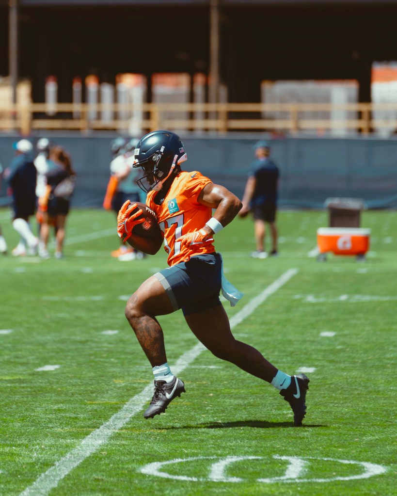 RJ Harvey runs with the football during Broncos rookie minicamp under sunny skies in Englewood, Colorado.