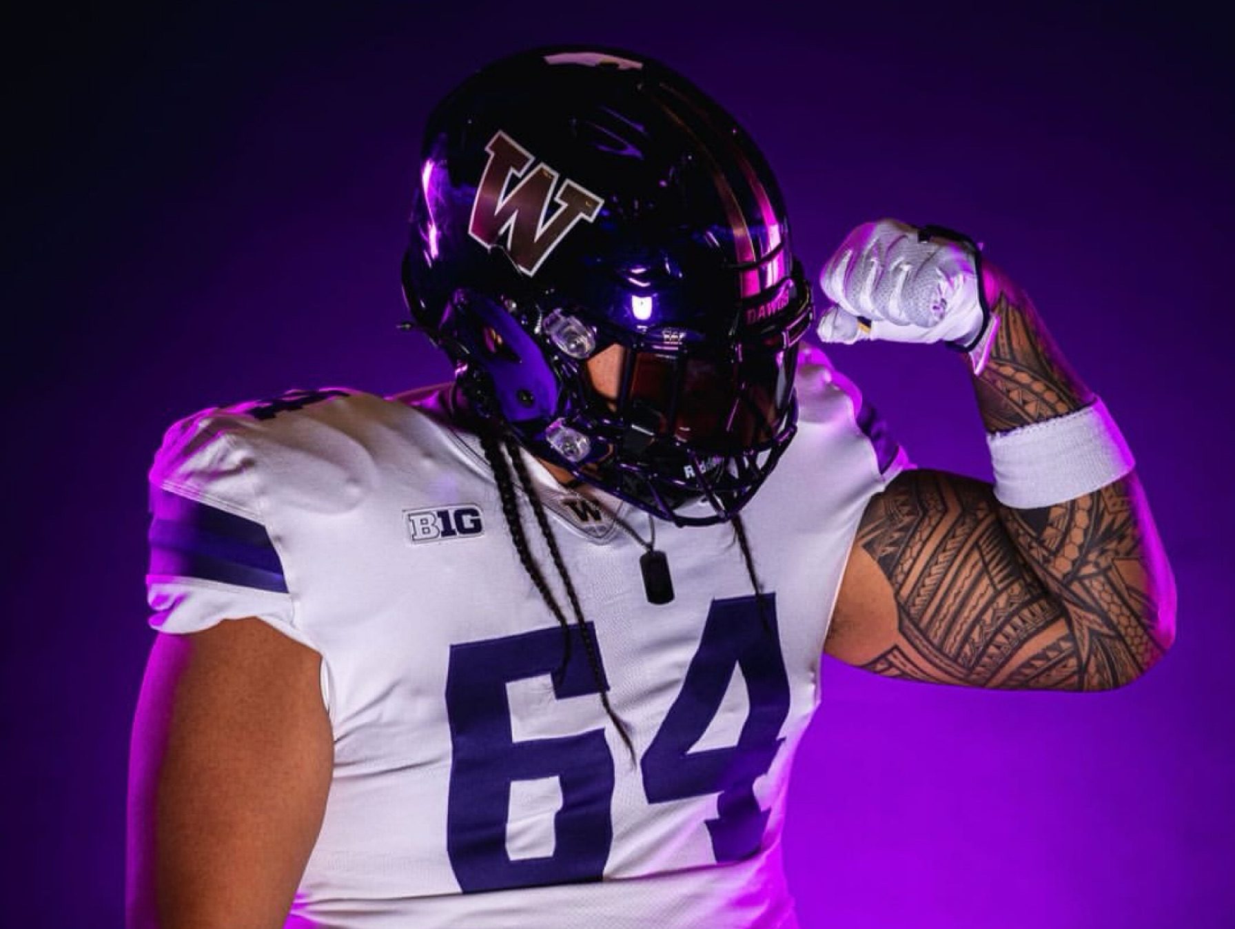 T.I. Umu-Cais in a University of Washington Huskies football uniform posing confidently on the field