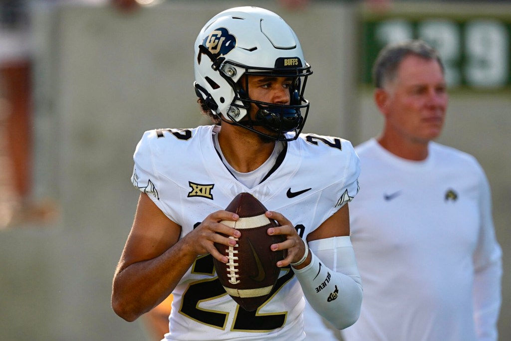 Colorado Buffaloes players and coaches huddle during spring practice while honoring late quarterback Dominiq Ponder