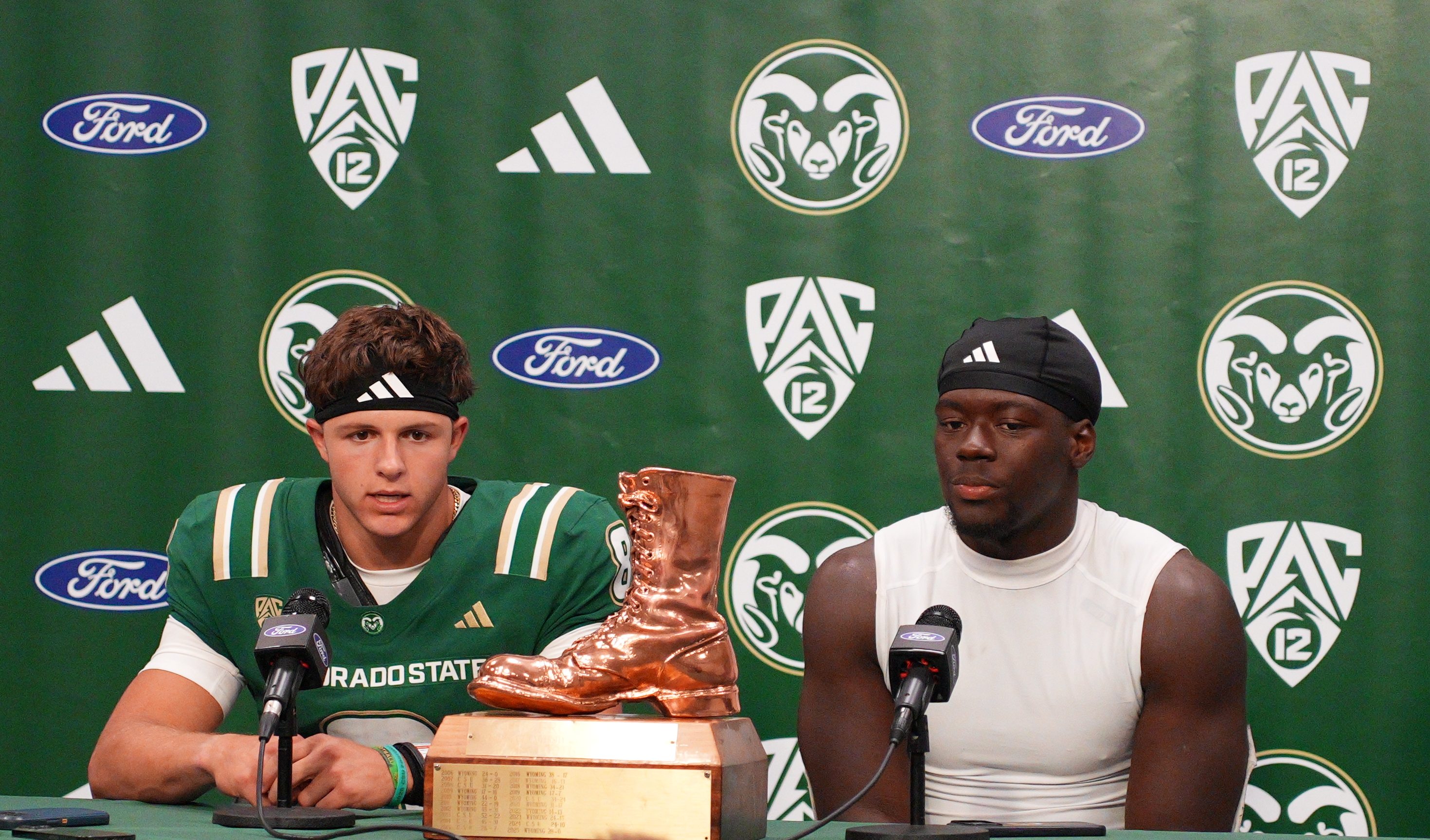 Colorado State quarterback Hauss Hejny and linebacker Oumar Diomande sit beside the Bronze Boot trophy during the postgame press conference after CSU’s 35-13 win over Wyoming in the 2026 Border War.